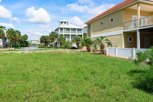 a view of a house with a yard and potted plants