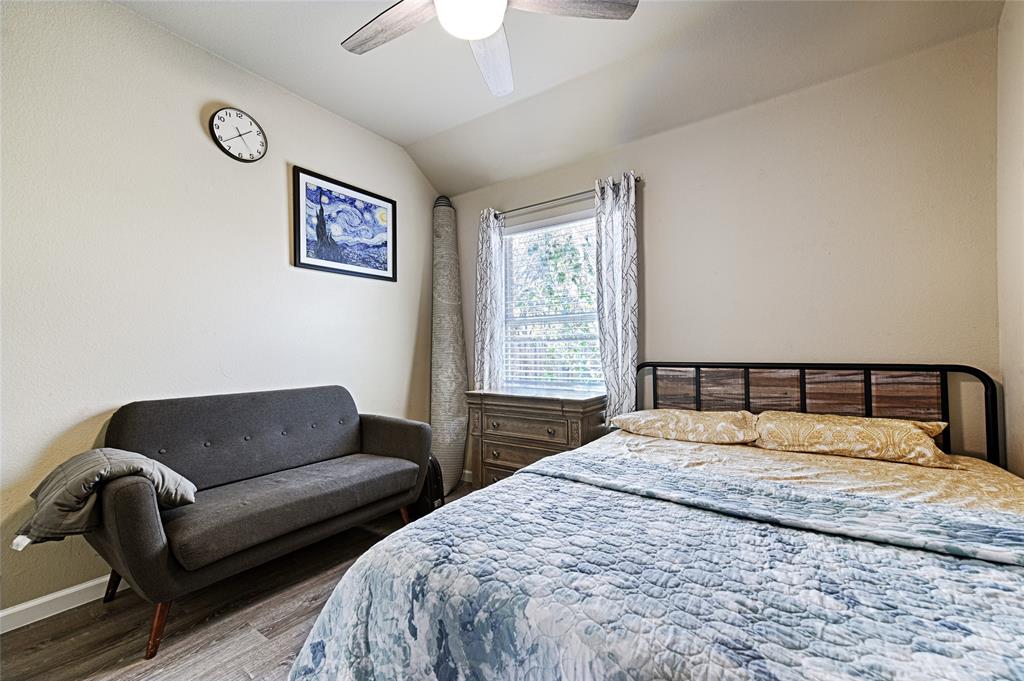 2704 Spring Drive McKinney, TX 75072 - Photo 20 of 35 a bedroom with a bed a couch and a chandelier