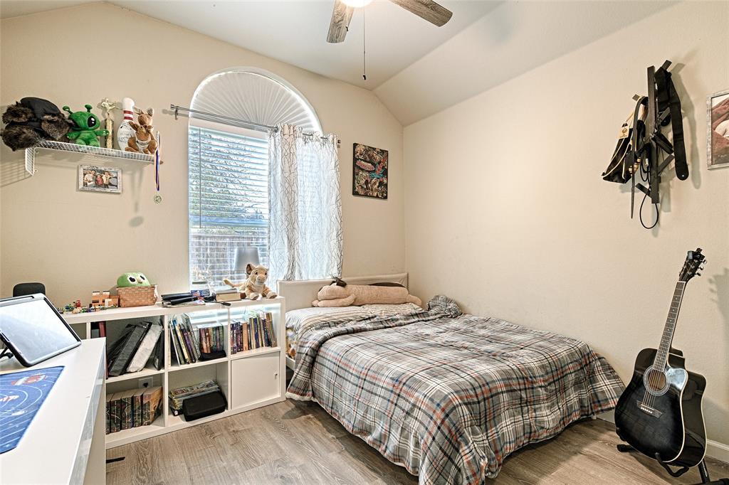 2704 Spring Drive McKinney, TX 75072 - Photo 22 of 35 a bedroom with a bed and a chandelier