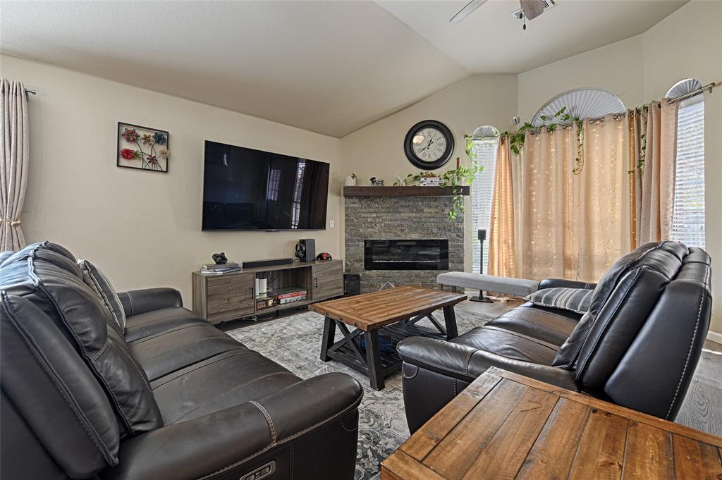 2704 Spring Drive McKinney, TX 75072 - Photo 3 of 35 a living room with furniture a flat screen tv and a fireplace