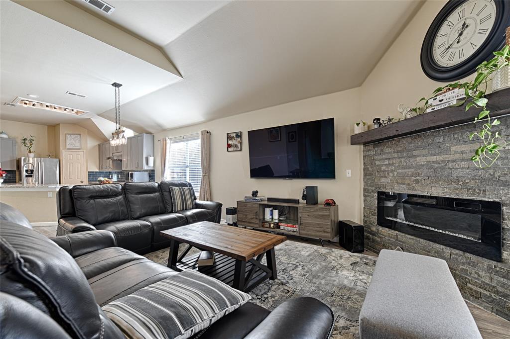 2704 Spring Drive McKinney, TX 75072 - Photo 4 of 35 a living room with furniture a flat screen tv and a fireplace
