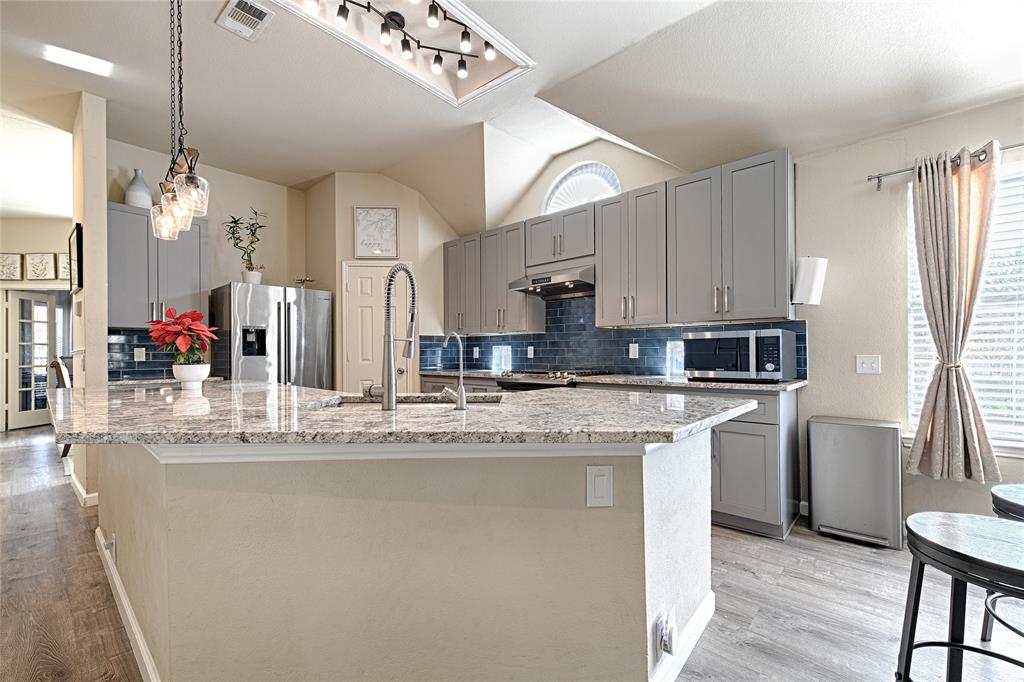 2704 Spring Drive McKinney, TX 75072 - Photo 7 of 35 a kitchen with stainless steel appliances granite countertop a sink refrigerator and cabinets