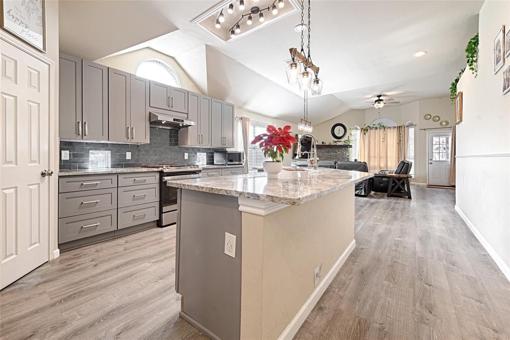 2704 Spring Drive McKinney, TX 75072 - Photo 8 of 35 a kitchen with granite countertop a sink cabinets and wooden floor