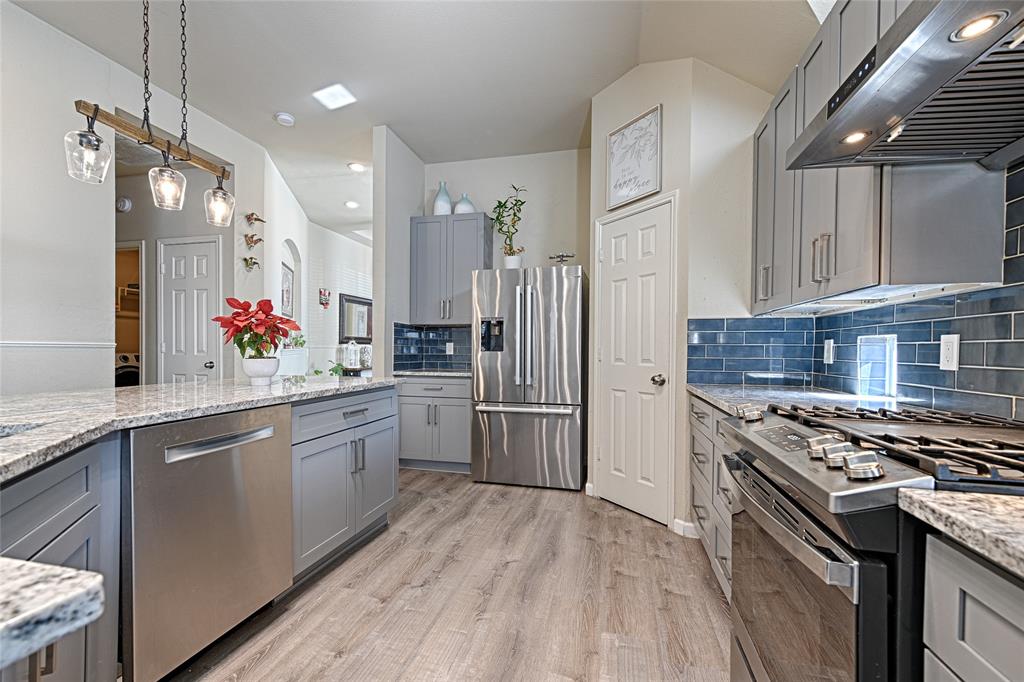 2704 Spring Drive McKinney, TX 75072 - Photo 10 of 35 a large kitchen with stainless steel appliances granite countertop a stove refrigerator and cabinets
