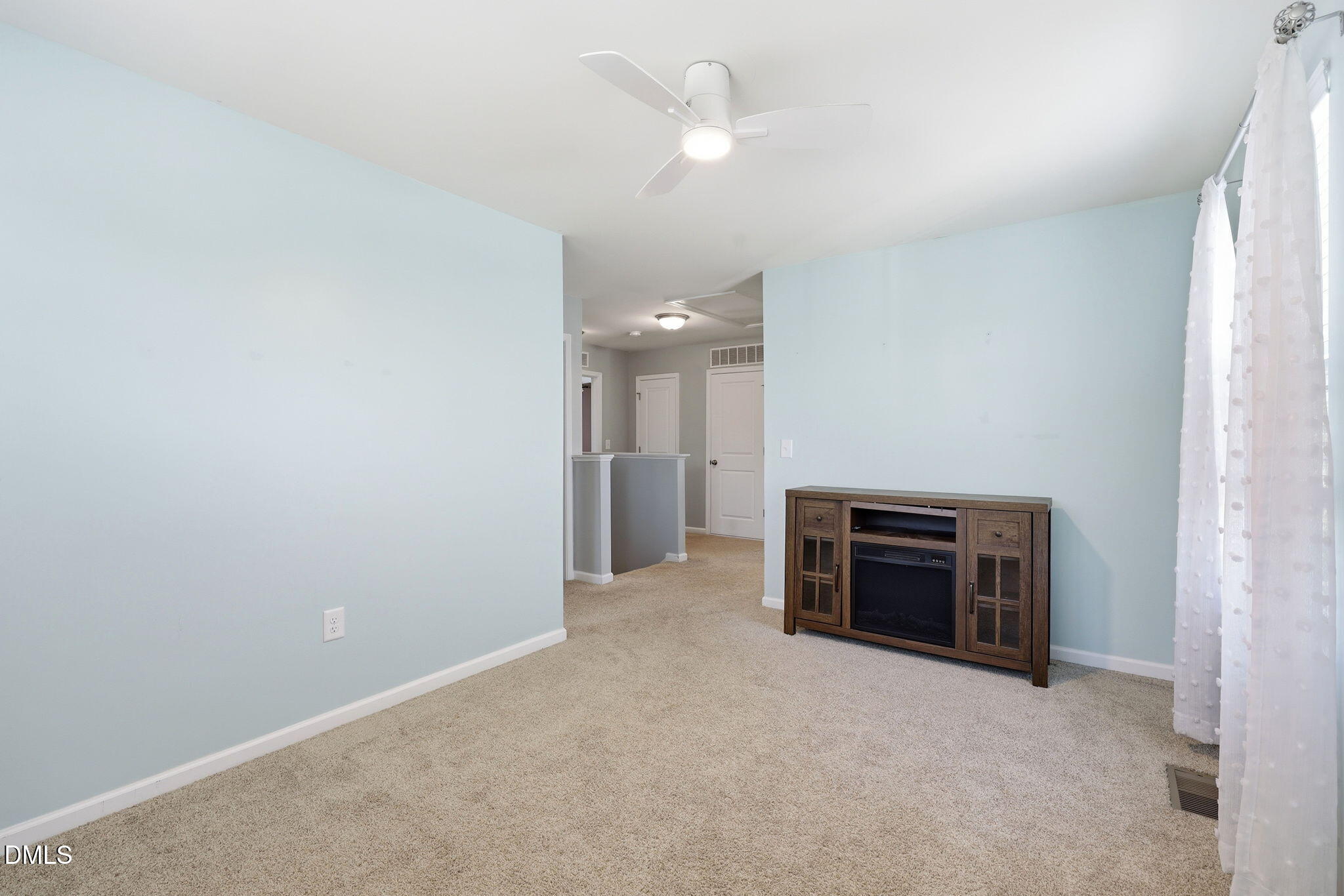1808 Austin Rdg Parkway Wake Forest, NC 27587 - Photo 23 of 57 an empty room with a fireplace and a ceiling fan