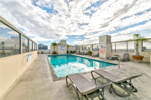 an outdoor patio with swimming pool and furniture