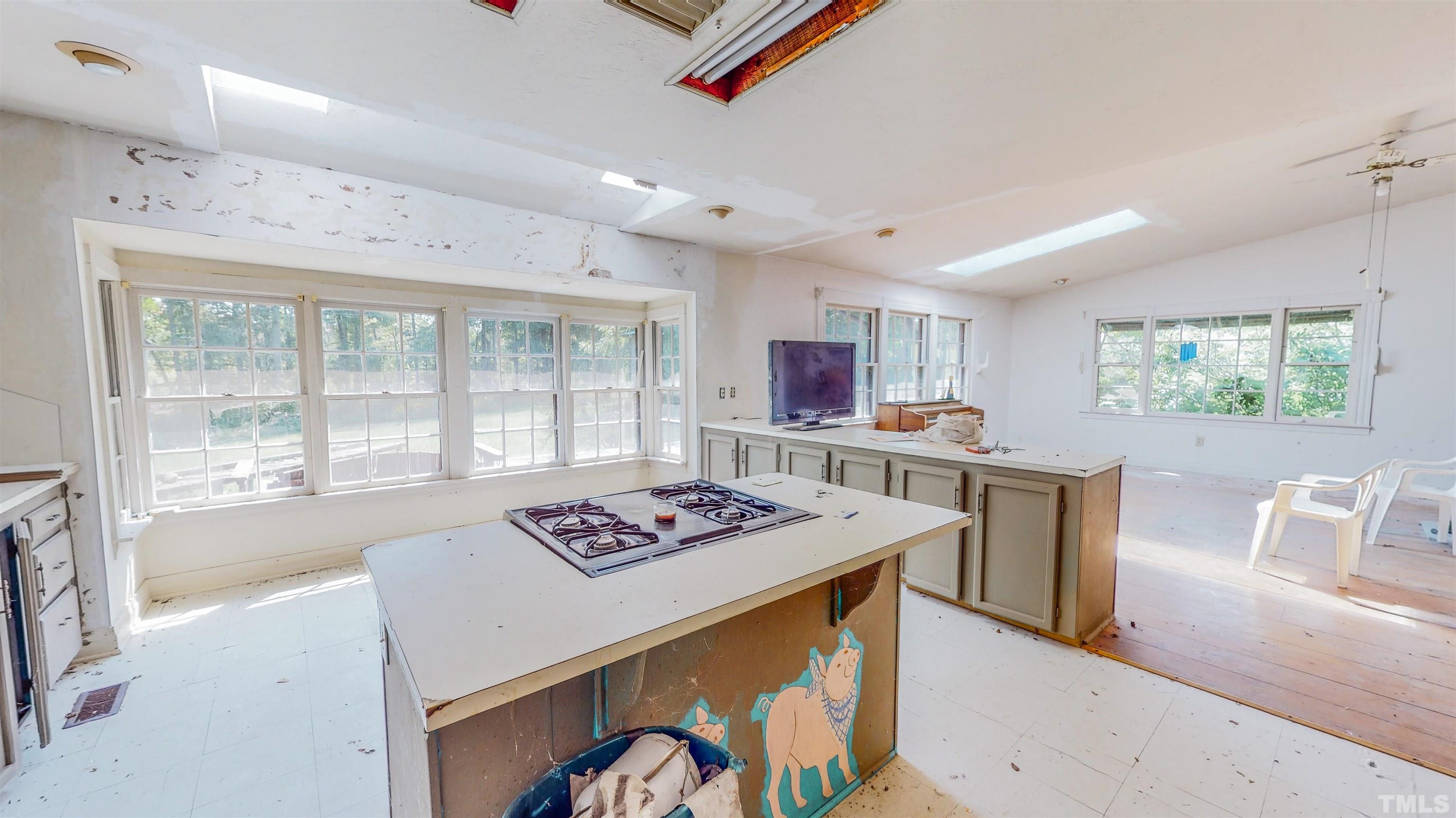 3640 Old Allensville Road Roxboro, NC 27574 - Photo 23 of 94 a open kitchen with stainless steel appliances granite countertop a stove top oven a sink dishwasher and white cabinets with wooden floor