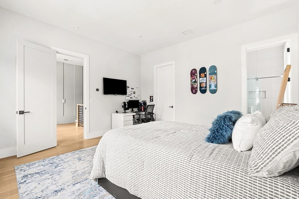 180 Allen Avenue Newton, MA 02468 - Photo 18 of 36 a bedroom with a bed a tv and wooden floor