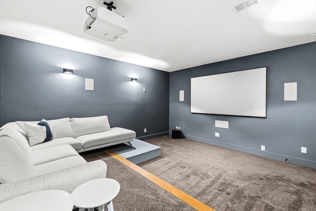 180 Allen Avenue Newton, MA 02468 - Photo 28 of 36 a living room with furniture and a projector screen