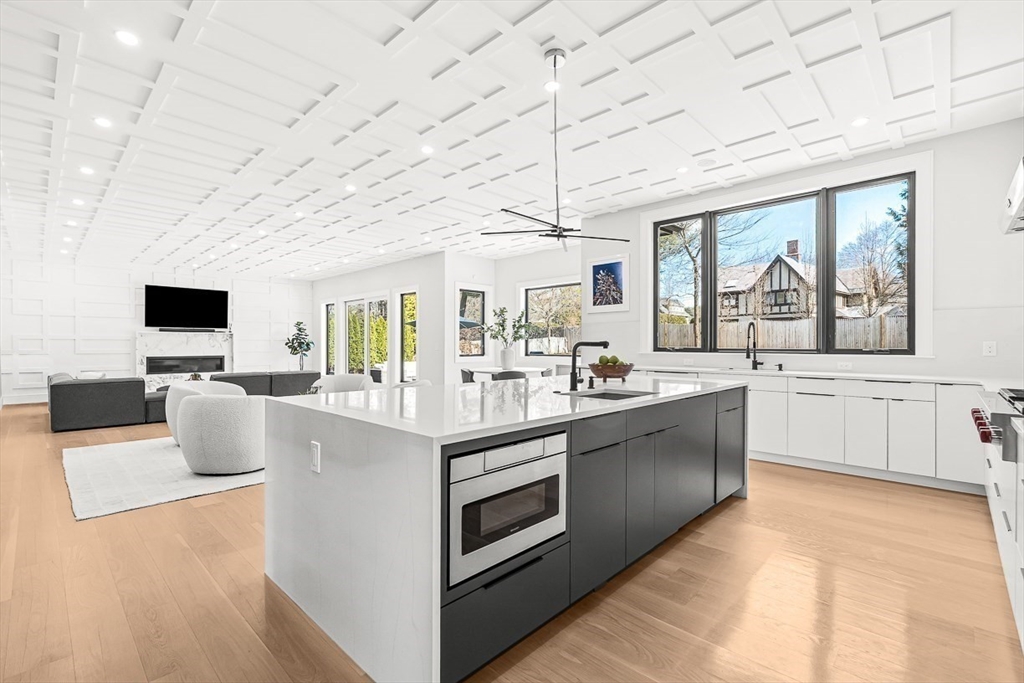 180 Allen Avenue Newton, MA 02468 - Photo 6 of 36 a large kitchen with stainless steel appliances granite countertop a large stove a sink dishwasher and white cabinets with wooden floor