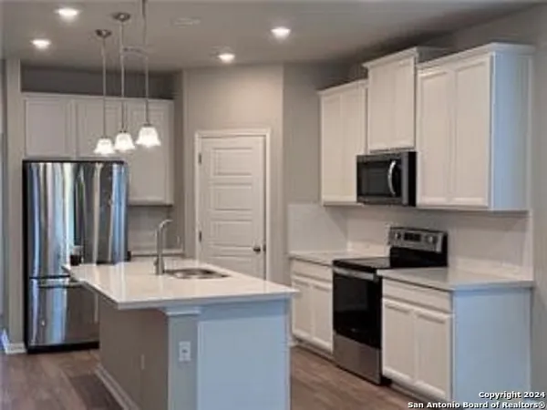 a kitchen with a sink stainless steel appliances and cabinets