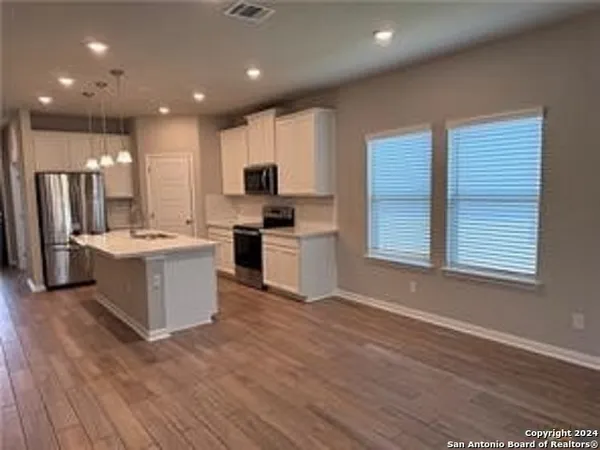 a large kitchen with stainless steel appliances kitchen island granite countertop a stove a sink and a refrigerator