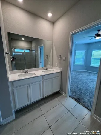 a bathroom with a double vanity sink a mirror and a shower