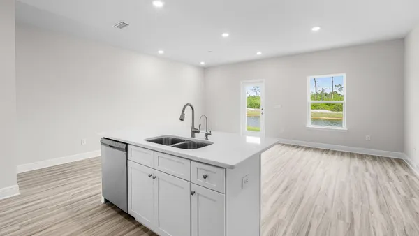 a kitchen with a refrigerator and white cabinets