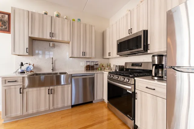 a kitchen with white cabinets a sink and a stove