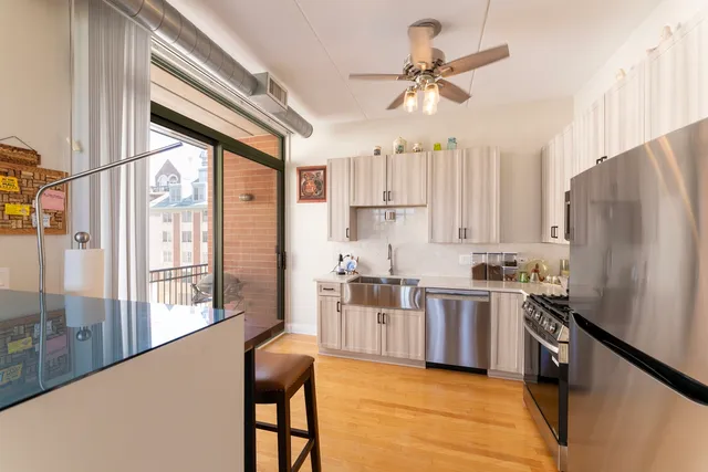 a kitchen with stainless steel appliances a stove a refrigerator and a kitchen island