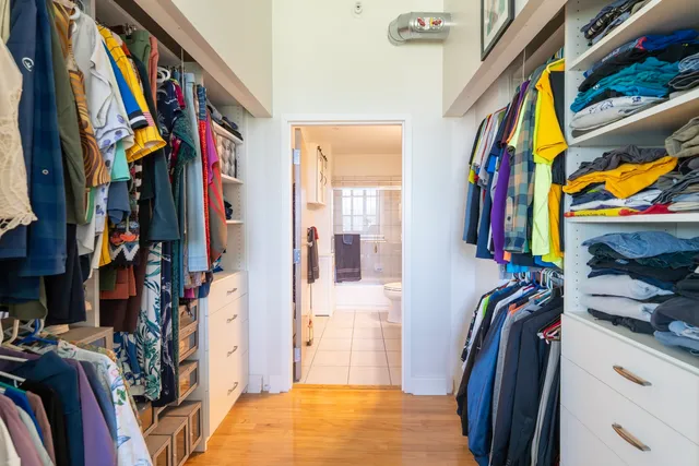 a view of walk in closet with clothes and shoes