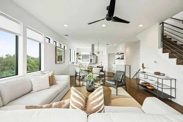 a kitchen with a table chairs refrigerator and wooden floor