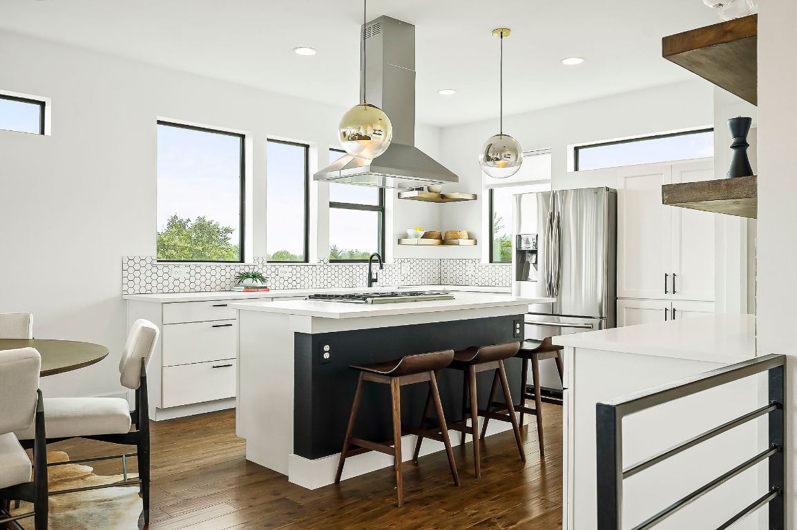 1104 Marcy Street, Unit B Austin, TX 78745 - Photo 15 of 34 a kitchen with a table chairs refrigerator and wooden floor