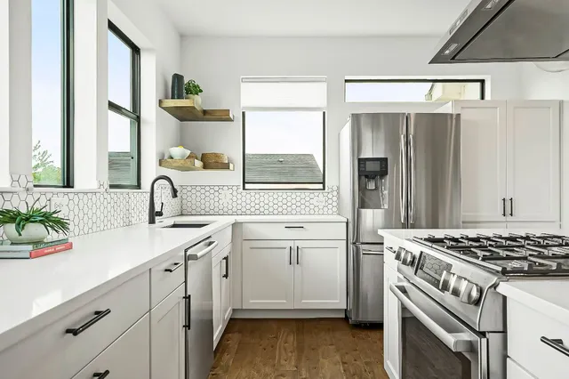 a kitchen with a stove a counter space dining table and chairs