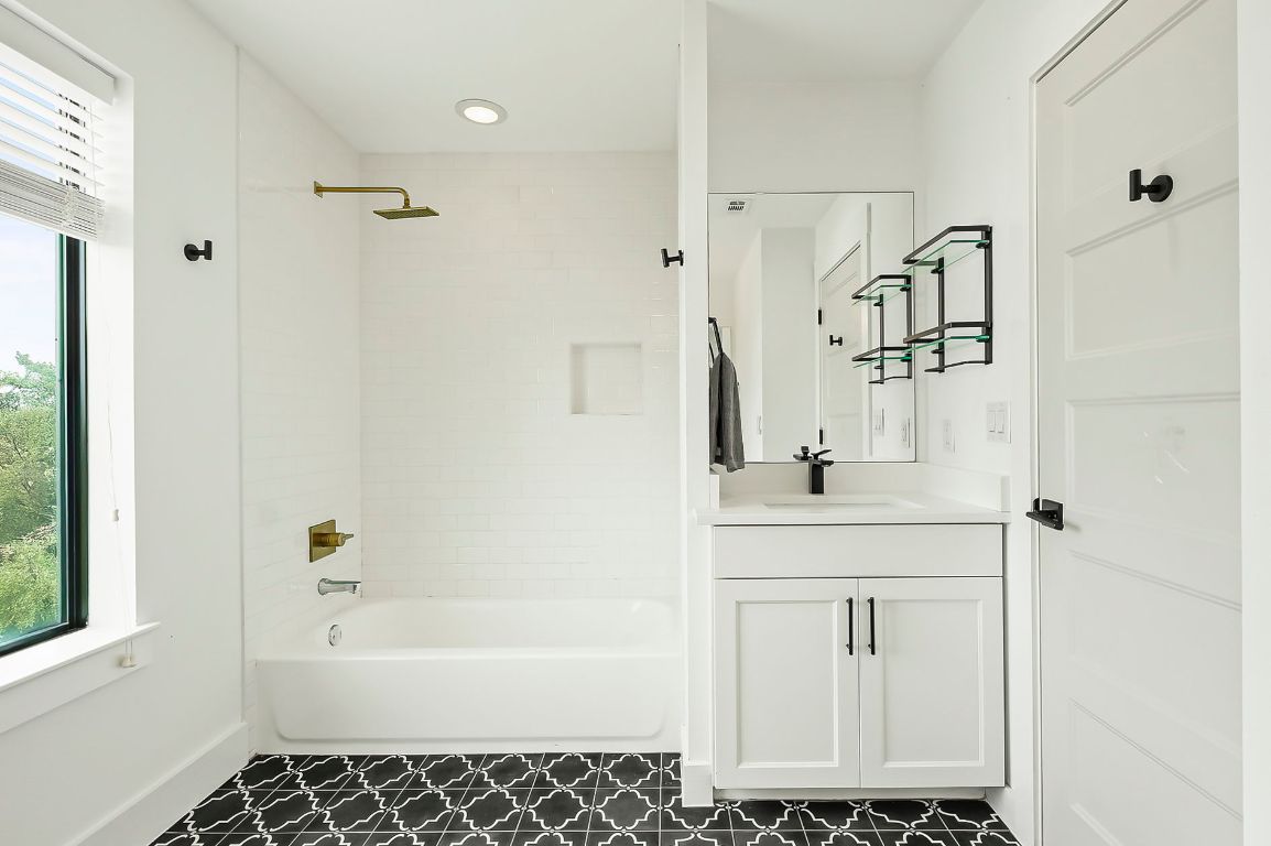 1104 Marcy Street, Unit B Austin, TX 78745 - Photo 25 of 34 a bathroom with a bathtub sink a mirror and shower