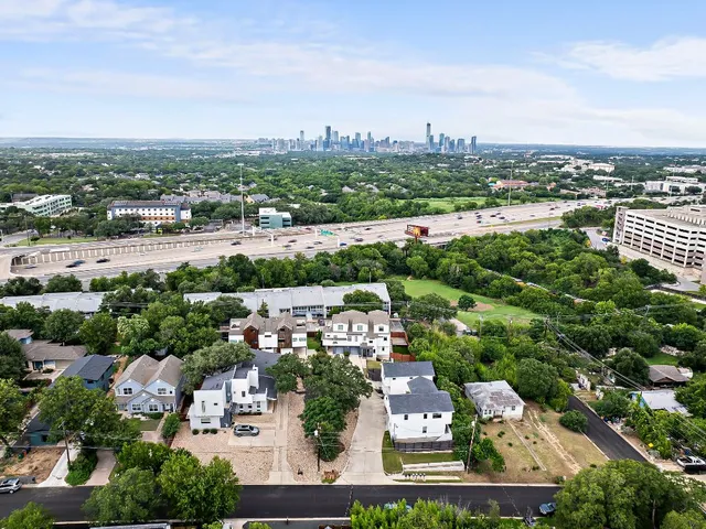 a view of a city with tall buildings and a cars park in front of it