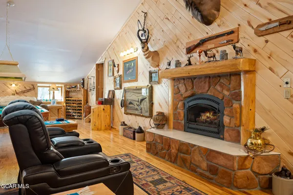 a living room with furniture a fireplace and a floor to ceiling window