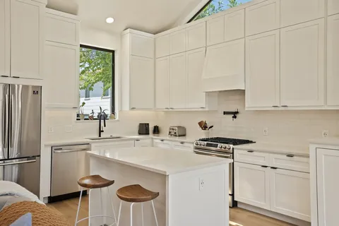a kitchen with granite countertop white cabinets and white appliances