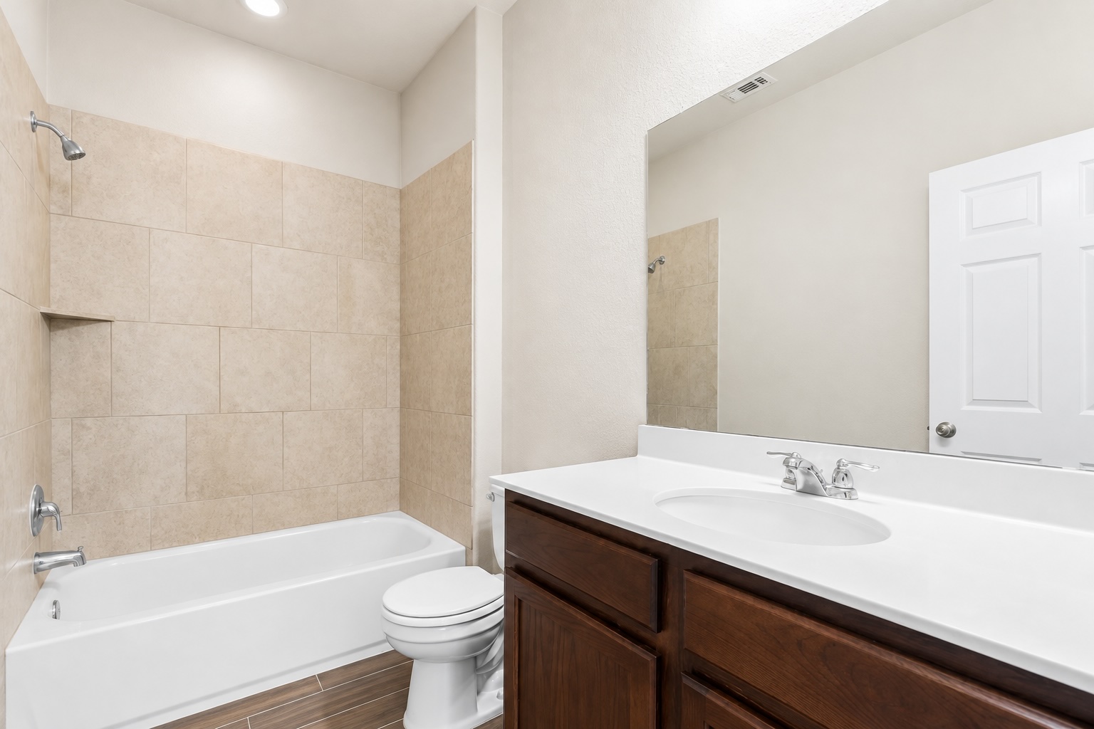 121 Guemal Road Buda, TX 78610 - Photo 11 of 13 A classic bathtub sits beside a warm wood vanity under a large mirror.