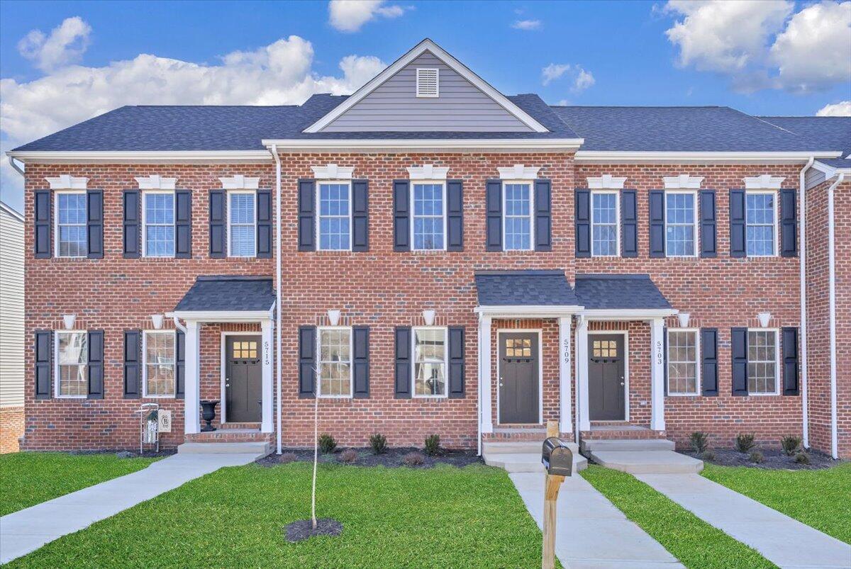 front view of a brick house with a yard