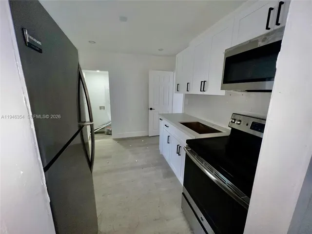 a kitchen with sink and refrigerator