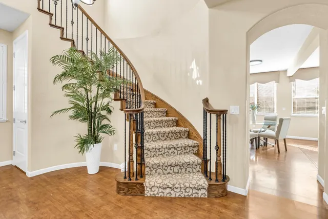 a view of a dining room with furniture a rug and wooden floor