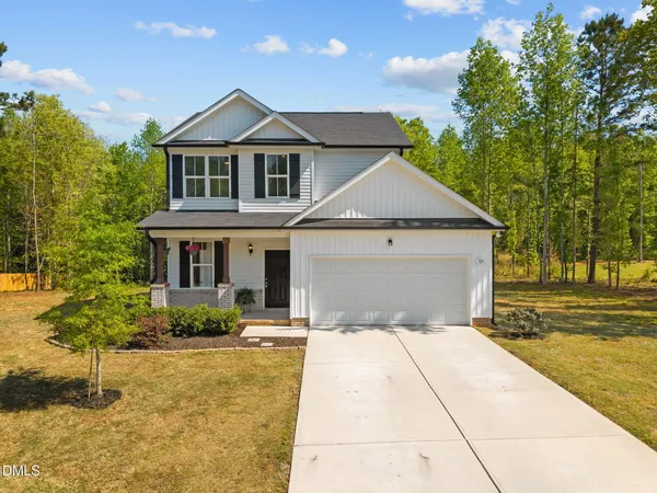 a front view of a house with a yard garage and outdoor seating