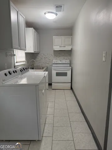 a utility room with cabinets washer and dryer