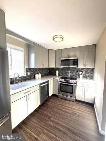 a kitchen with granite countertop white cabinets and white appliances