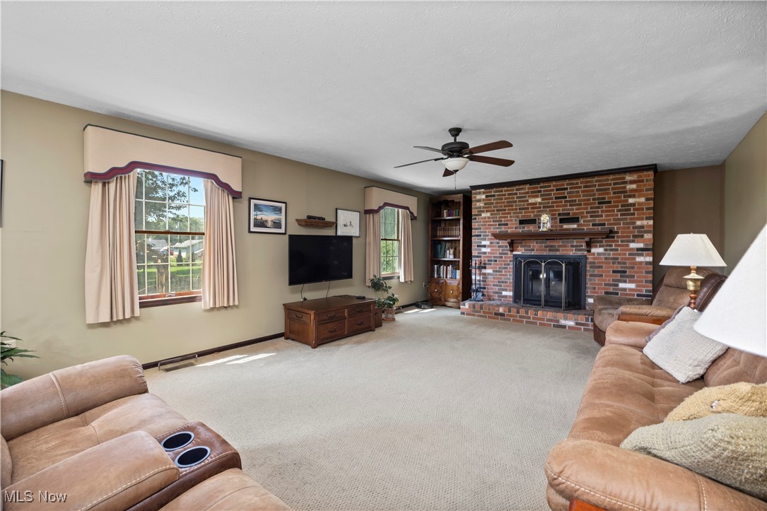 319 Ironwood Road Huron, OH 44839 - Photo 11 of 32 Living room with plenty of natural light, carpet, a fireplace, and ceiling fan