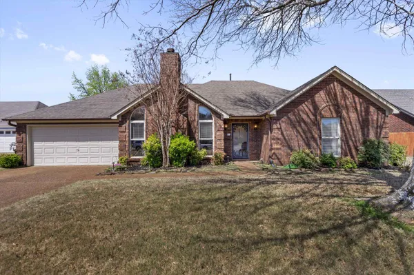 a view of a house with a yard and tree s
