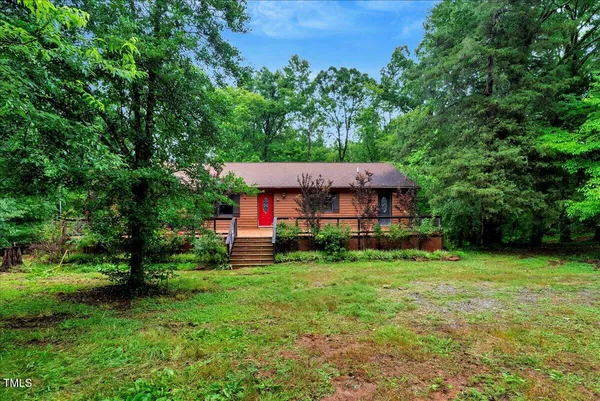 a view of a house with a yard and lawn chairs