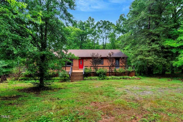 a view of a house with a yard and lawn chairs