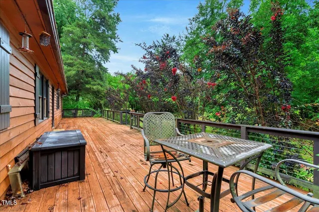 a backyard of a house with deck and outdoor seating