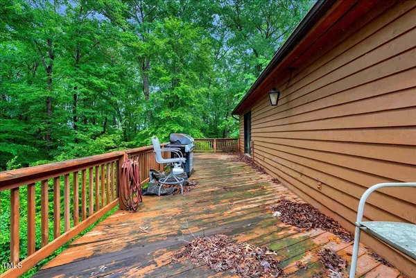 a backyard of a house with plants and large tree