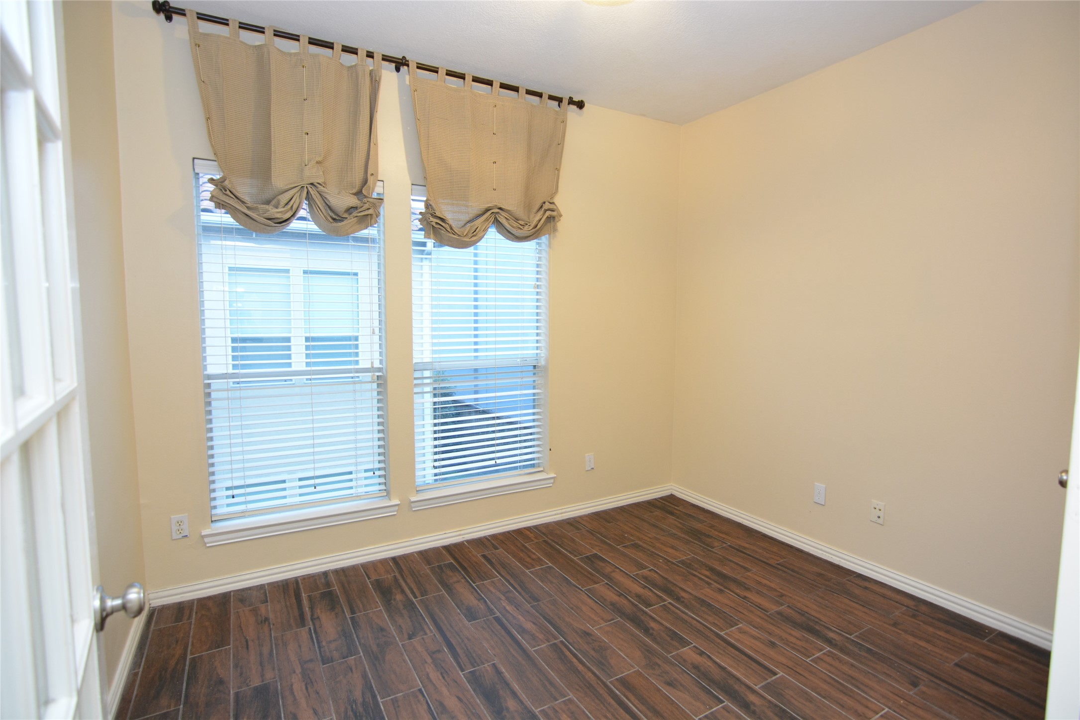 6119 Windwater Pointe Houston, TX 77036 - Photo 16 of 23 a view of an empty room with wooden floor and a window