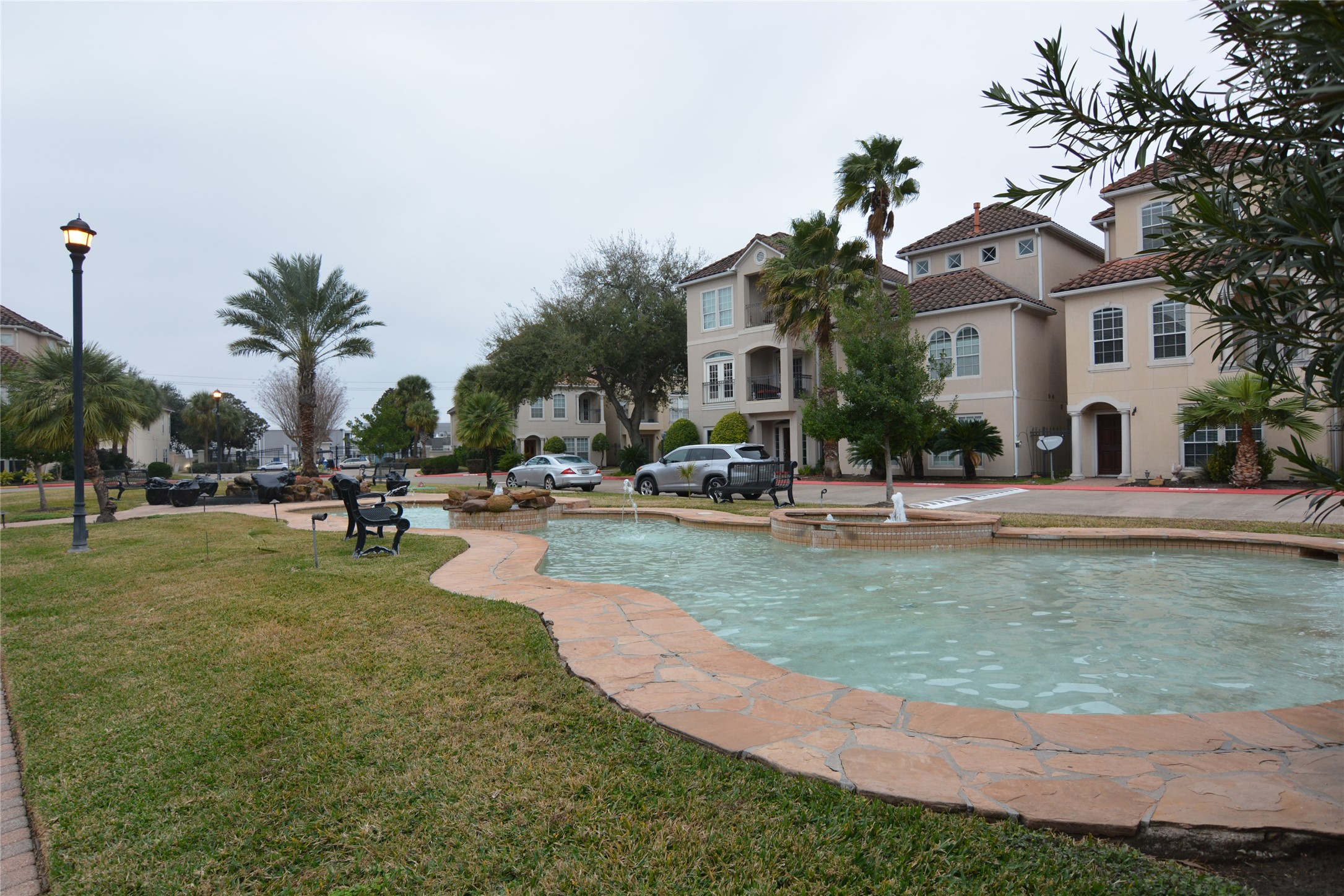 6119 Windwater Pointe Houston, TX 77036 - Photo 23 of 23 a view of a white house with a swimming pool and lawn chairs