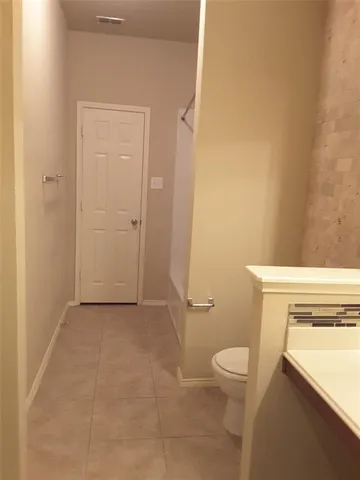 a bathroom with a granite countertop toilet and a sink