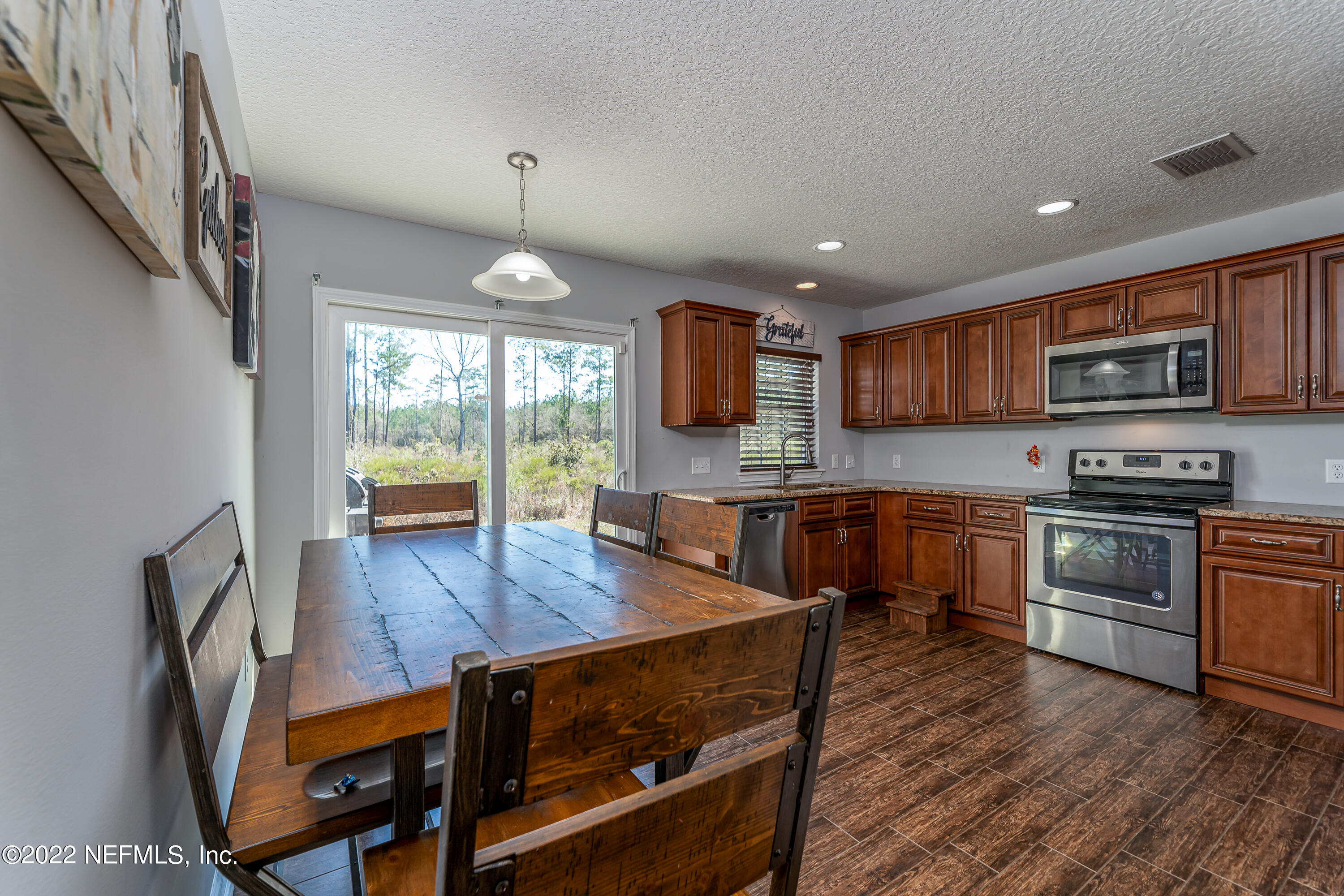 9143 McClelland Road Jacksonville, FL 32234 - Photo 14 of 37 a kitchen with stainless steel appliances granite countertop a stove top oven a sink a counter space and cabinets