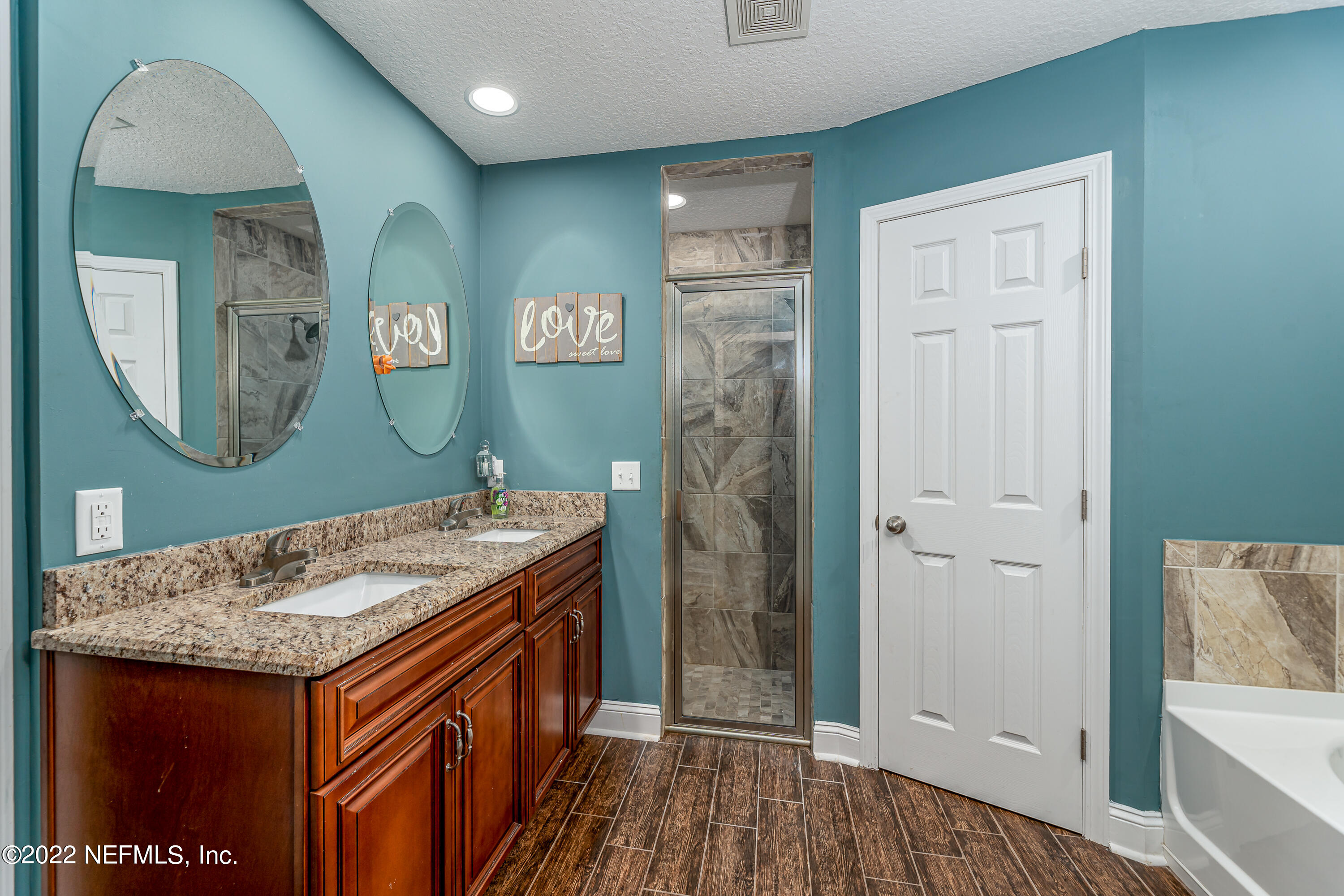 9143 McClelland Road Jacksonville, FL 32234 - Photo 16 of 37 a bathroom with a sink a mirror and a shower