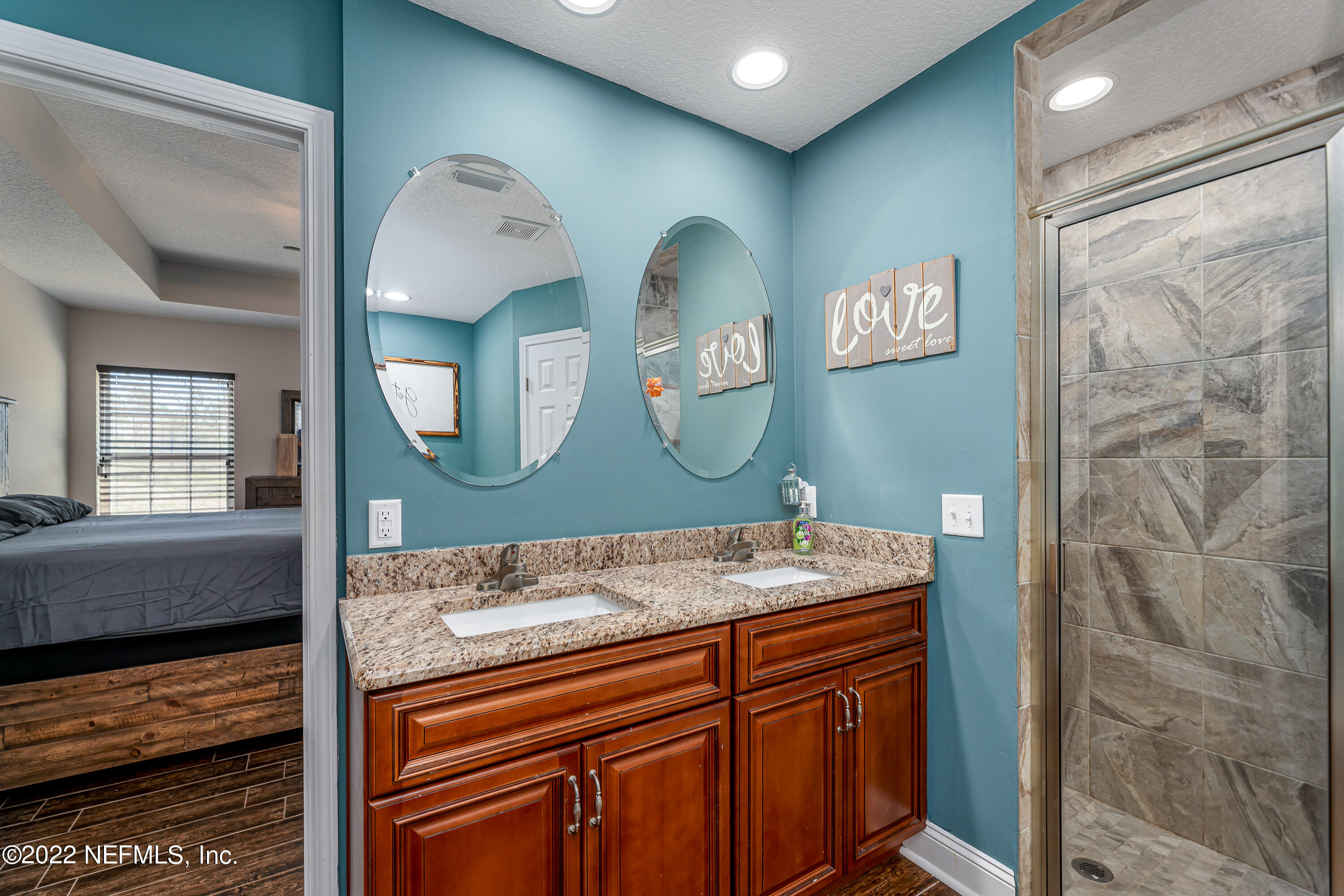 9143 McClelland Road Jacksonville, FL 32234 - Photo 17 of 37 a bathroom with a sink a mirror and a shower