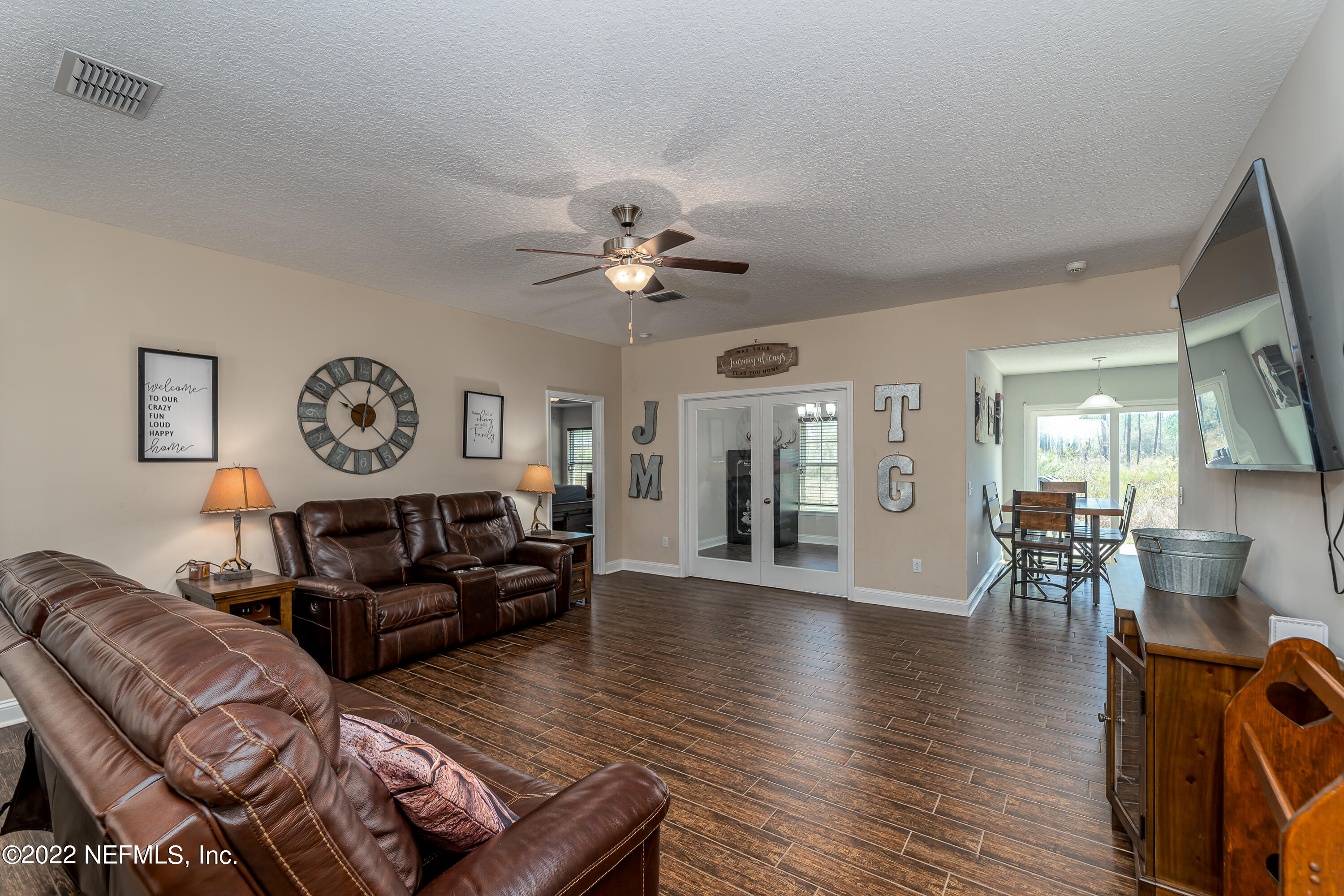 9143 McClelland Road Jacksonville, FL 32234 - Photo 9 of 37 a living room with furniture a two couches and a large mirror with wooden floor