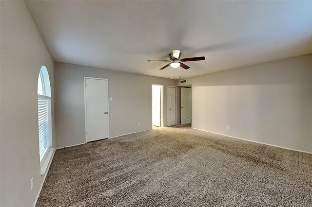 a view of an empty room with a chandelier fan