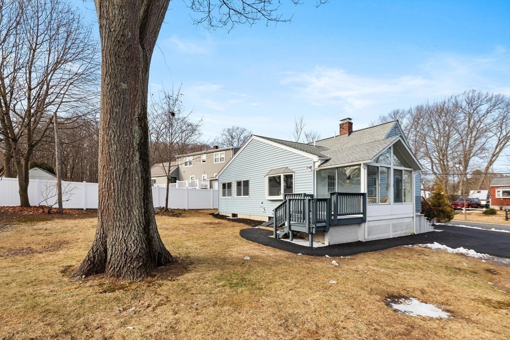 49 Butler Avenue Stoneham, MA 02180 - Photo 35 of 36 a view of a white house next to a road yard and a large tree